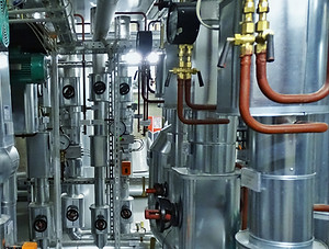 Technikzentrale mit blechummantelten Rohrleitungen, Armaturen und Behältern